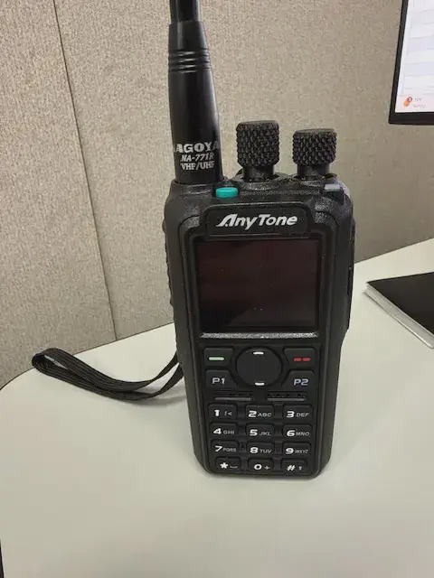 anytone d878uvii front view with black antenna attached black textured body two control knobs lcd display control buttons numeric keypad