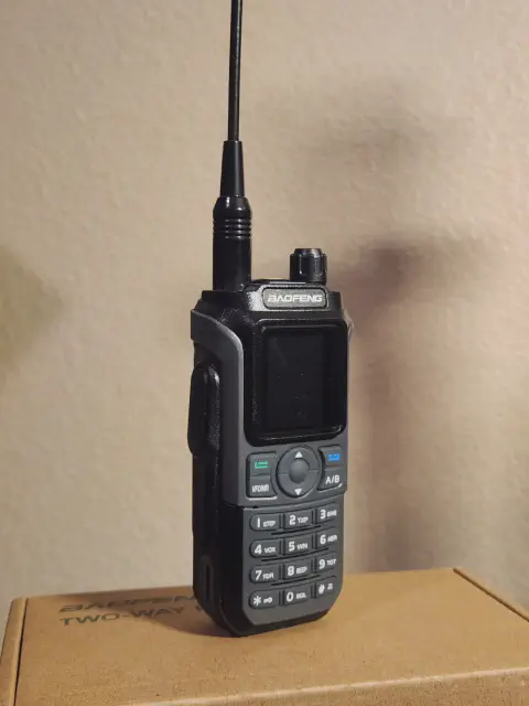 baofeng btech uv 21r front view with black antenna attached grey smooth and black textured body single control knob lcd display control buttons numeric keypad