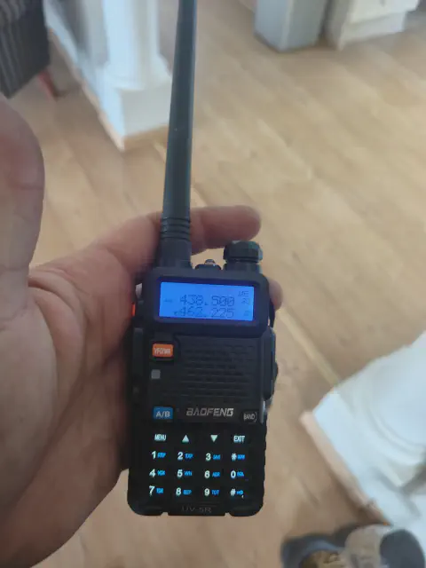 baofeng btech uv 5r front view with black antenna attached black textured body single control knob lcd display control buttons numeric keypad