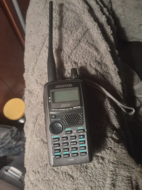 kenwood th d72a front view with black antenna attached black smooth body single stacked control knob lcd display control buttons numeric keypad speaker grille