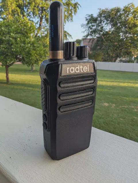 radtel rt 493 front view with black antenna attached black textured body two control knobs speaker grille