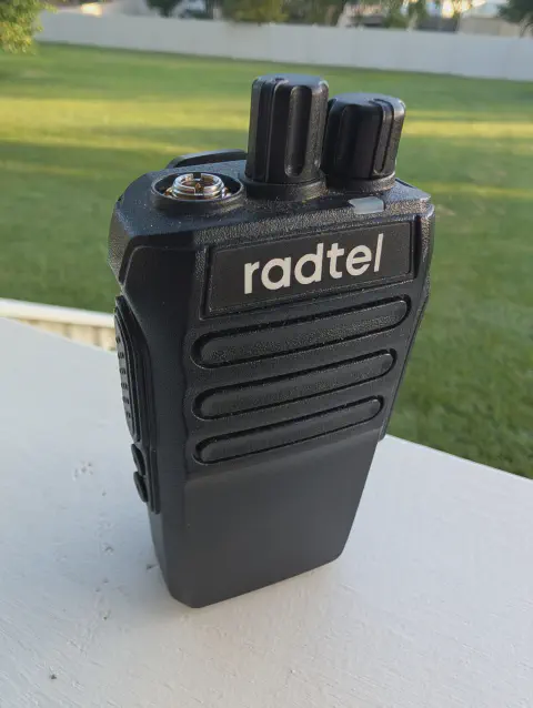 radtel rt 493 front view showing sma m connector without antenna black textured body two control knobs speaker grille
