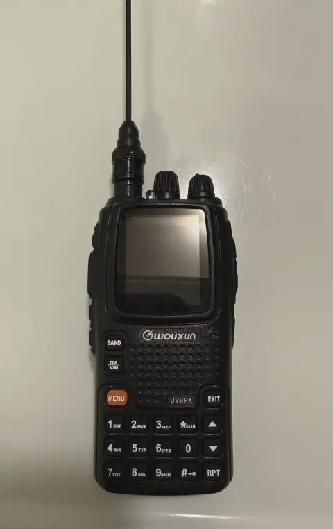 wouxun kg uv9px front view with black signal stick antenna attached black textured body two control knobs lcd display control buttons speaker grille numeric keypad