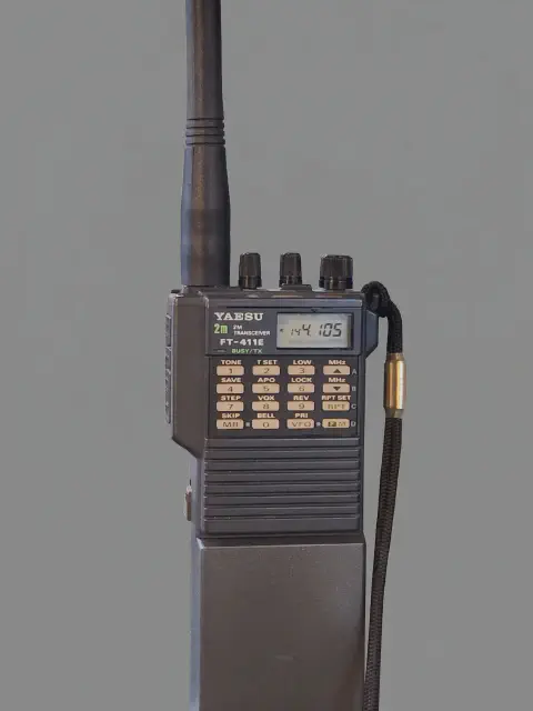 yaesu ft 411e front view with gray antenna attached gray textured body three control knobs lcd display numeric keypad speaker grille