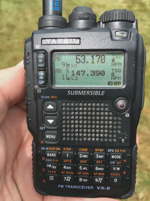 yaesu vertext vx 8dr front view with black antenna attached black textured body two control knobs lcd display control buttons speaker grille numeric keypad